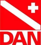Logotipo rojo de DAN con banda diagonal blanca y cruz en esquina superior, texto "DAN", relacionado con Nusa Penida.