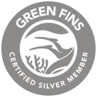 Sello circular gris que muestra a dos aletas de buceo sobre coral y dice "Green Fins Certified Silver Member", promocionando prácticas sostenibles en Nusa Penida.